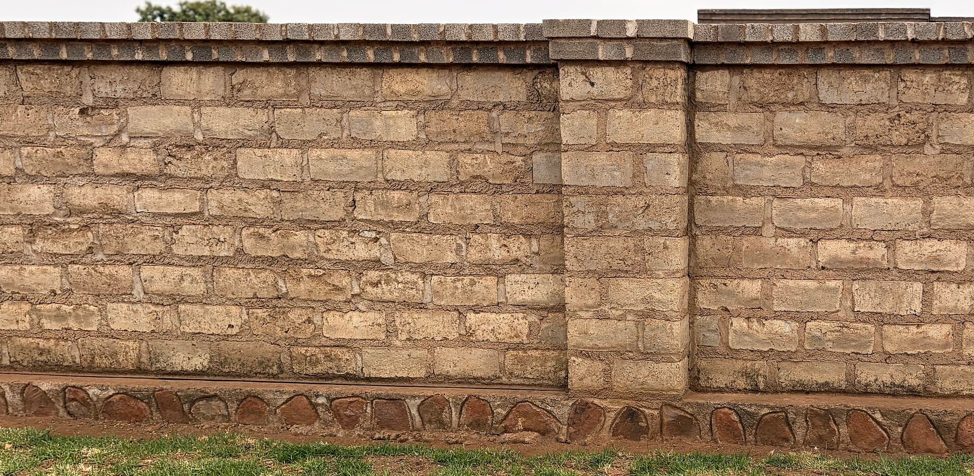 Brick boundary wall and piered masonry fence on an Australian suburban street