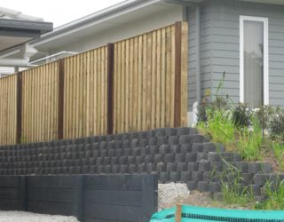 Overlapped and capped fence with exposed posts; block wall