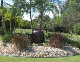Water feature in pebble garden with grasses